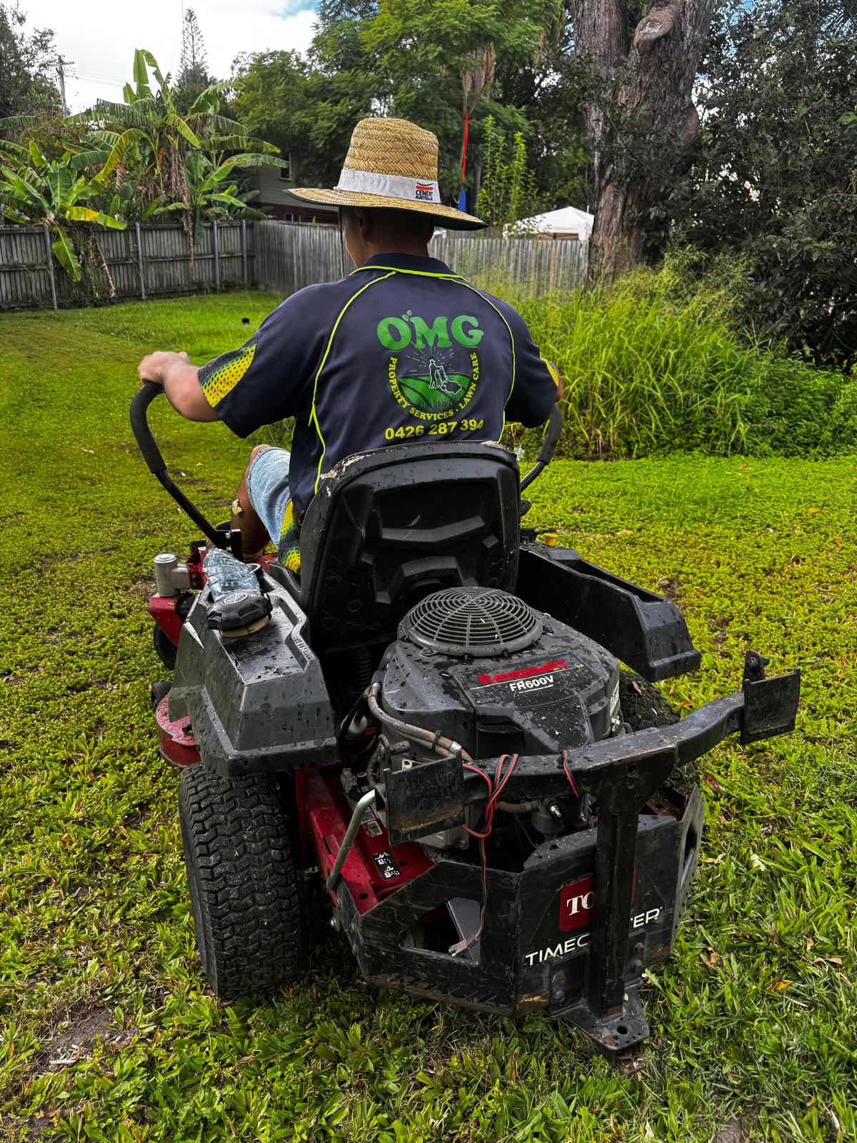 OMG Lawn Care operator mowing a Brisbane residential lawn
